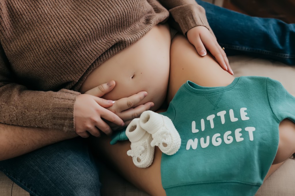 Pregnancy photo with baby clothes. Metro detroit newborn photographer