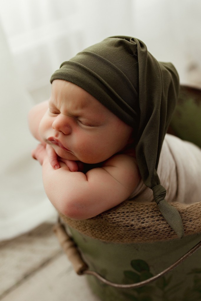sleeping baby newborn photos posed in a bucket