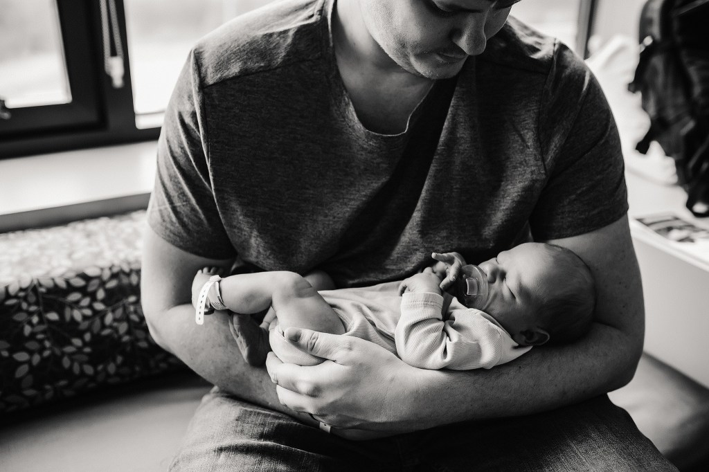 Dad holding new baby boy in the hospital
